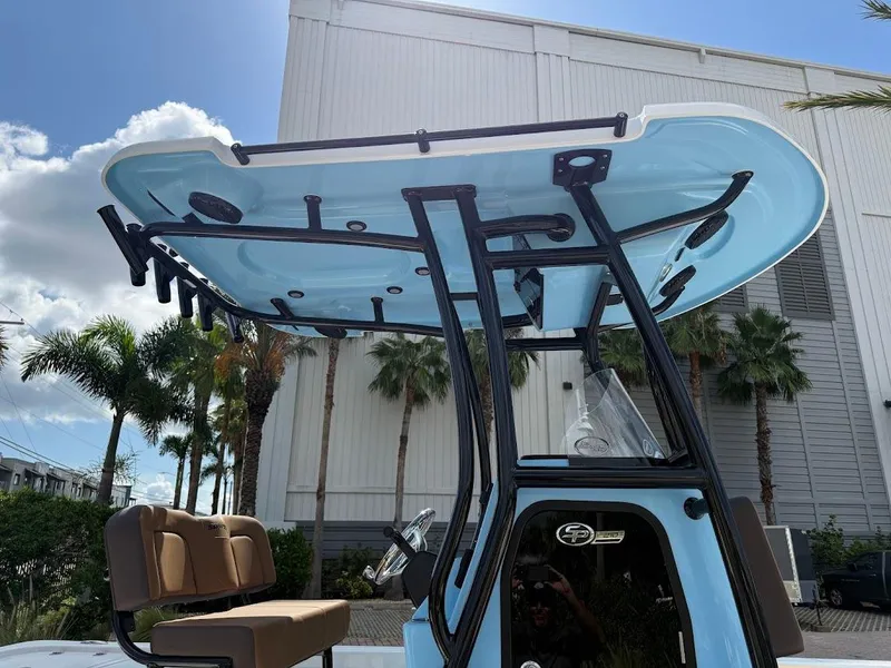 Slide: The Image of 2026 Sea Pro 210 Bay boat with T-top and seating, set against a tropical backdrop. - 7