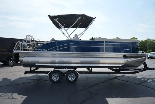 Slide: The Image of 2026 Harris Cruiser 230 pontoon boat on trailer, featuring a sleek blue design. - 3
