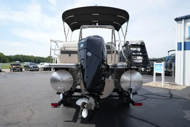 Slide: The Image of 2026 Harris Cruiser 230 pontoon boat with outboard motor, parked on a paved lot. - 5