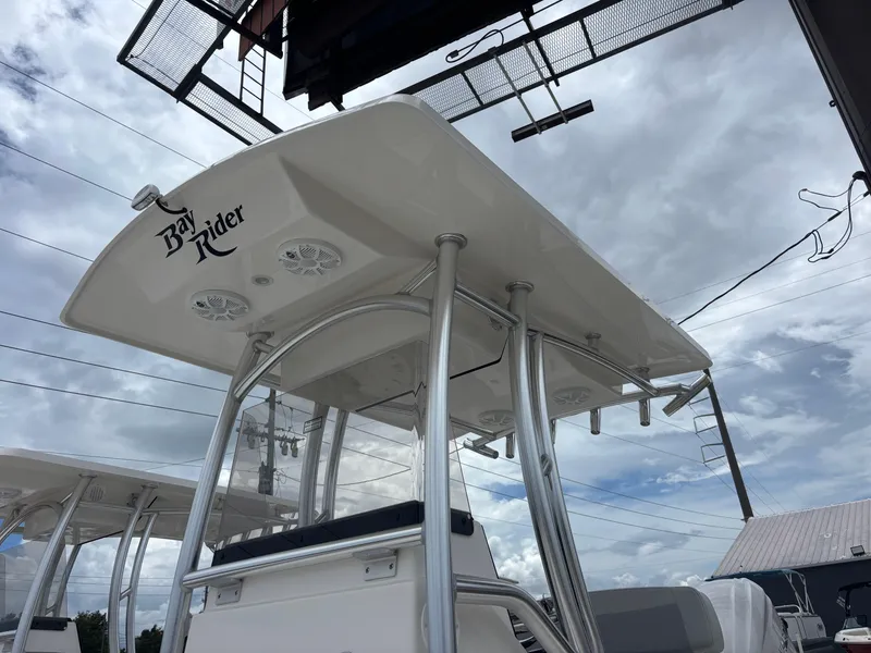 Slide: The Image of Bay Rider 239 Bay 2026 boat with T-top and speakers under cloudy sky. - 4