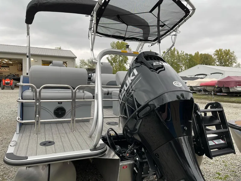 Slide: The Image of 2025 Bentley Pontoons Legacy 243 QSB with Suzuki outboard motor, docked outdoors. - 10