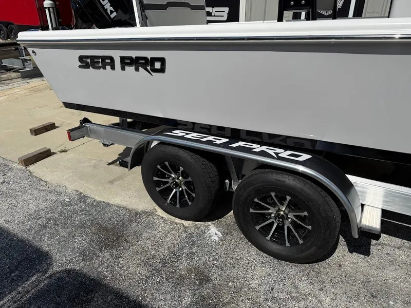 Slide: The Image of 2026 Sea Pro 250 Bay boat on trailer, showcasing sleek design and dual wheels. - 4