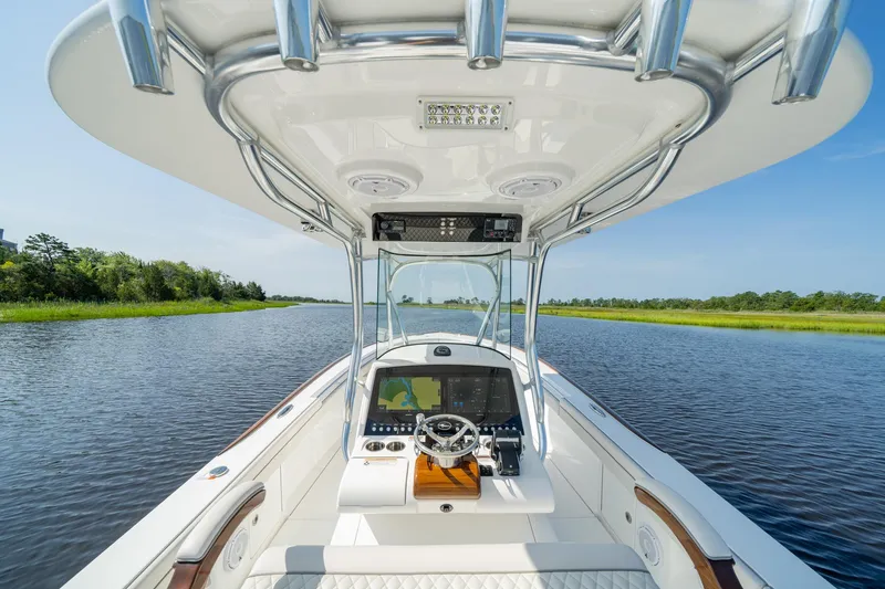 Slide: The Image of 2025 Valhalla Boatworks V-29 Hybrid on a serene river, showcasing modern helm and lush surroundings. - 11