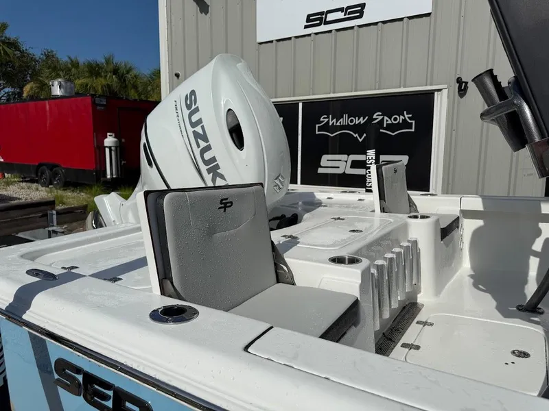 Slide: The Image of 2026 Sea Pro 230 Bay boat with Suzuki engine, docked near a red trailer. - 9