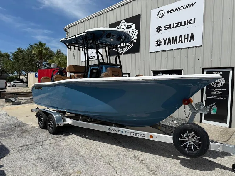 The Image of 2026 Sea Pro 225 Sandbar boat on trailer outside marine dealership. - 1
