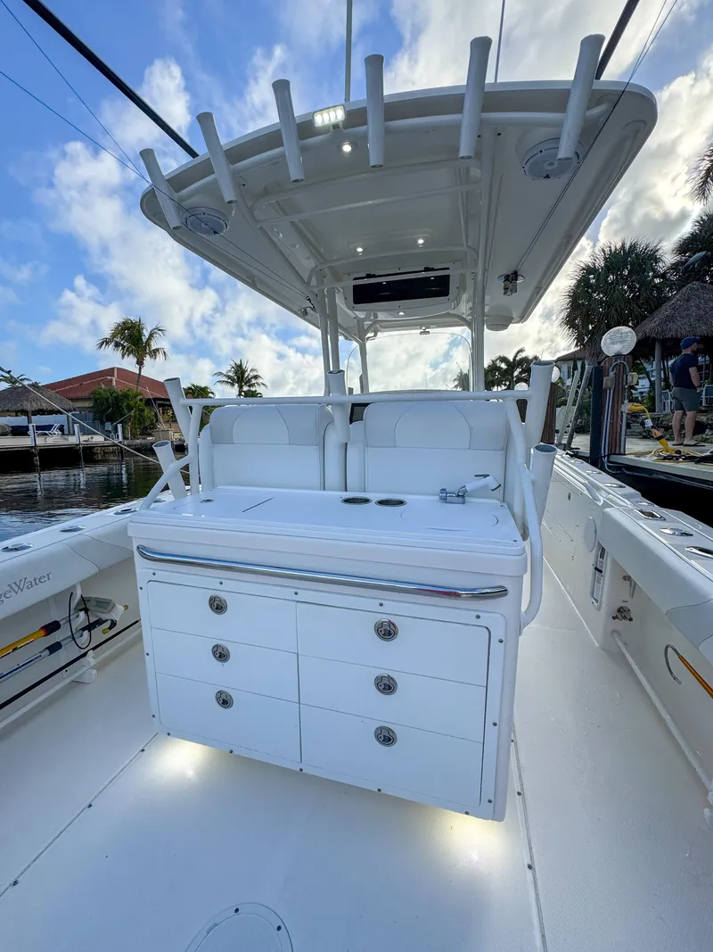 Slide: The Image of 2013 Edgewater 318CC boat interior with fishing rod holders and storage drawers. - 11