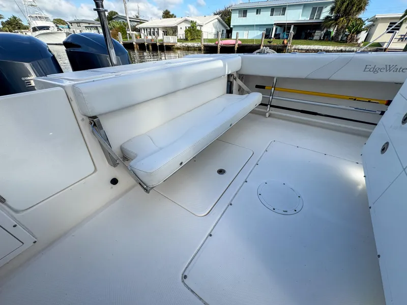 Slide: The Image of 2013 Edgewater 318CC boat interior with white seating and spacious deck. - 15