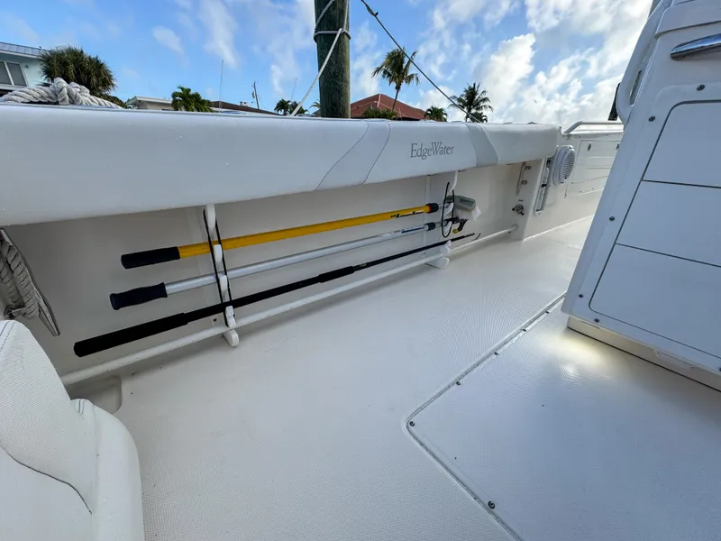 Slide: The Image of 2013 Edgewater 318CC boat interior with fishing rod storage and clear sky background. - 16