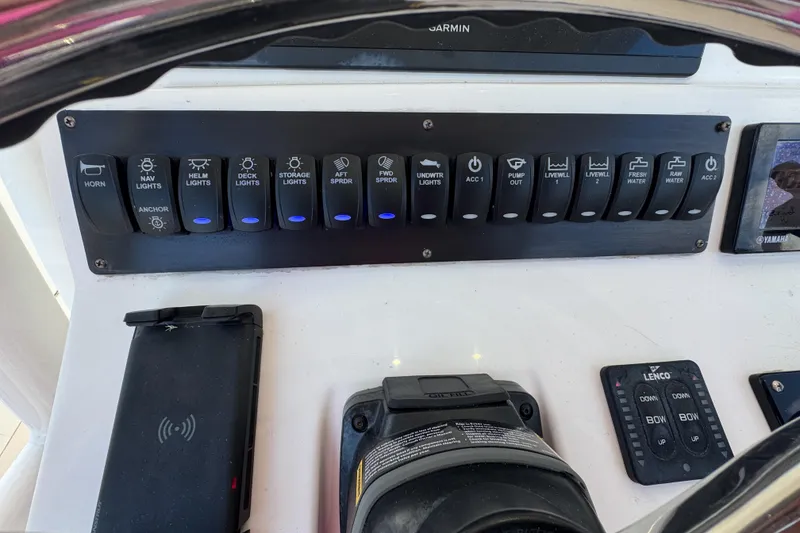 Slide: The Image of Control panel of a 2013 Edgewater 318CC boat with various switches and a phone dock. - 20