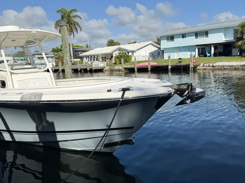 Slide: The Image of Edgewater 318CC boat docked by waterfront homes, clear sky, calm water, 2013 model. - 3