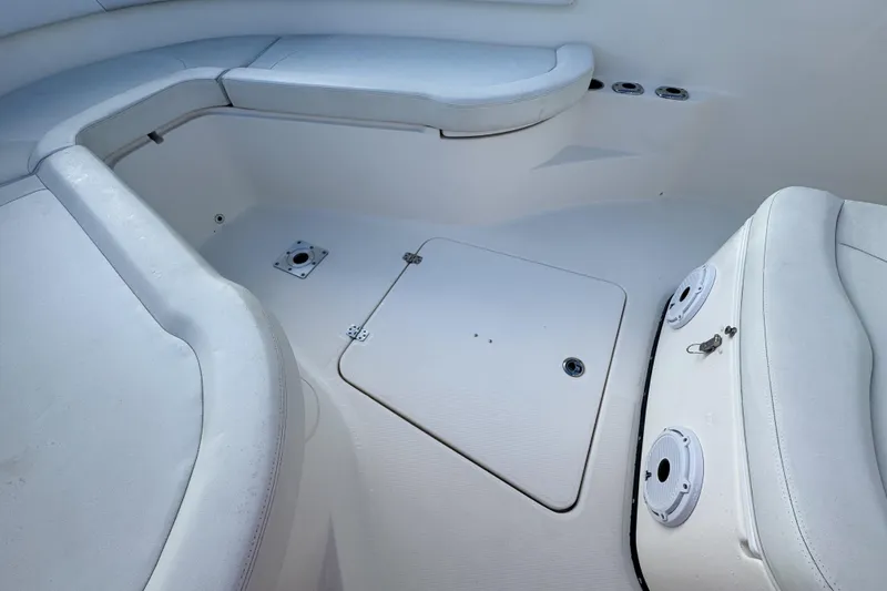 Slide: The Image of 2013 Edgewater 318CC boat interior with white seating and storage compartments. - 33