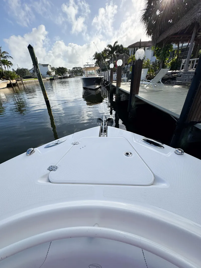 Slide: The Image of Bow view of 2013 Edgewater 318CC boat docked in a scenic waterfront setting. - 41