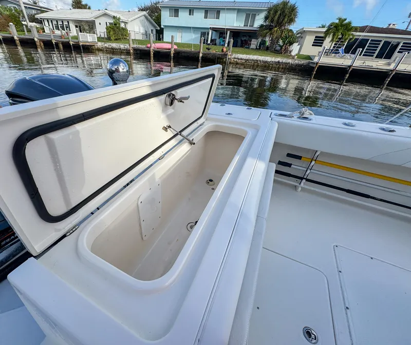 Slide: The Image of Open storage compartment on 2013 Edgewater 318CC boat by a waterfront dock. - 7