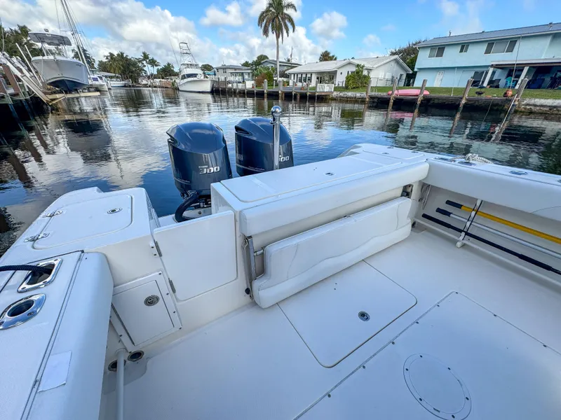 Slide: The Image of 2013 Edgewater 318CC boat with twin engines docked in a serene marina setting. - 9
