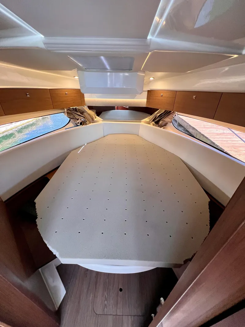 Slide: The Image of 2019 Jeanneau NC 1095 cabin interior with bed and wooden accents. - 12