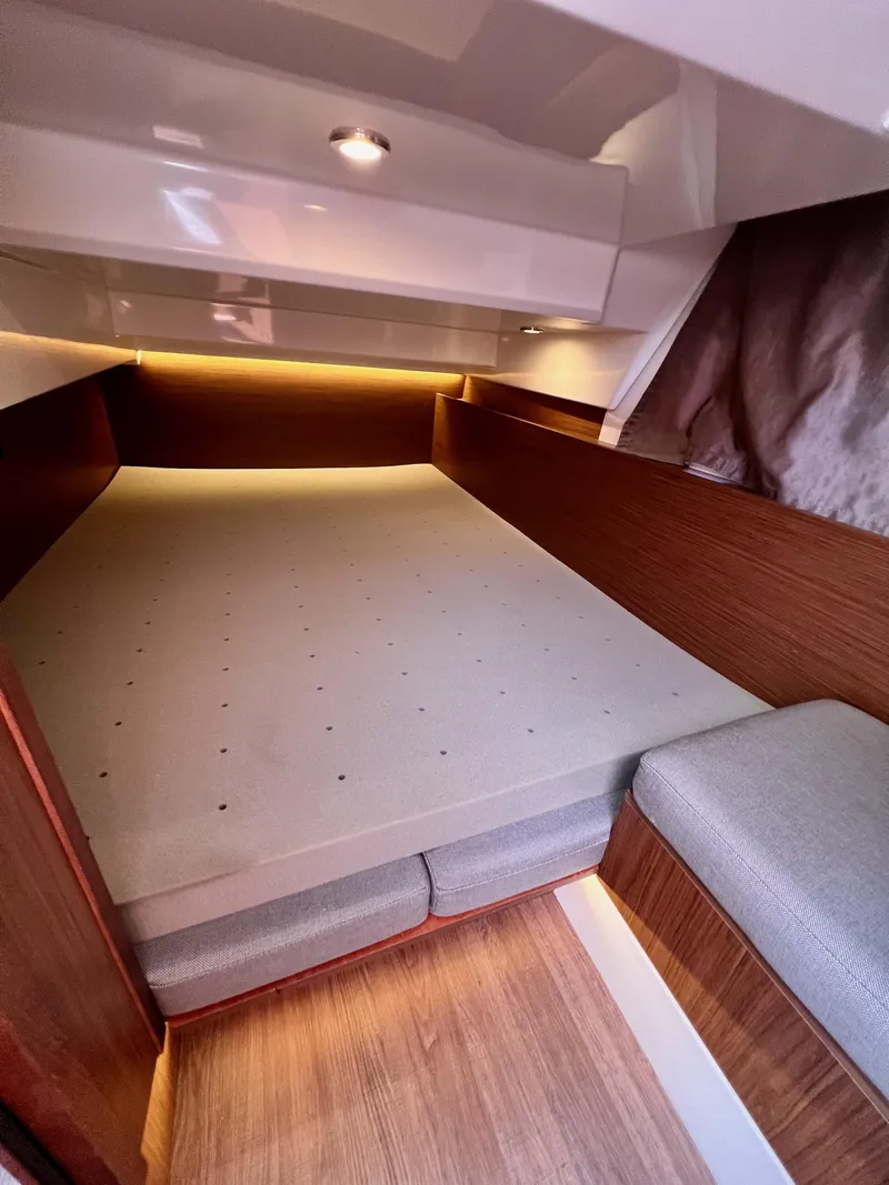 Slide: The Image of Cozy cabin interior of 2019 Jeanneau NC 1095 with wood accents and soft lighting. - 13