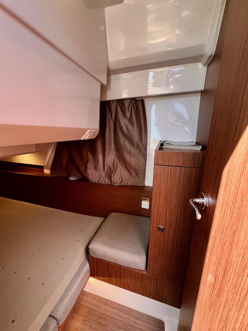 Slide: The Image of 2019 Jeanneau NC 1095 cabin interior with wood finish and cozy bedding. - 15