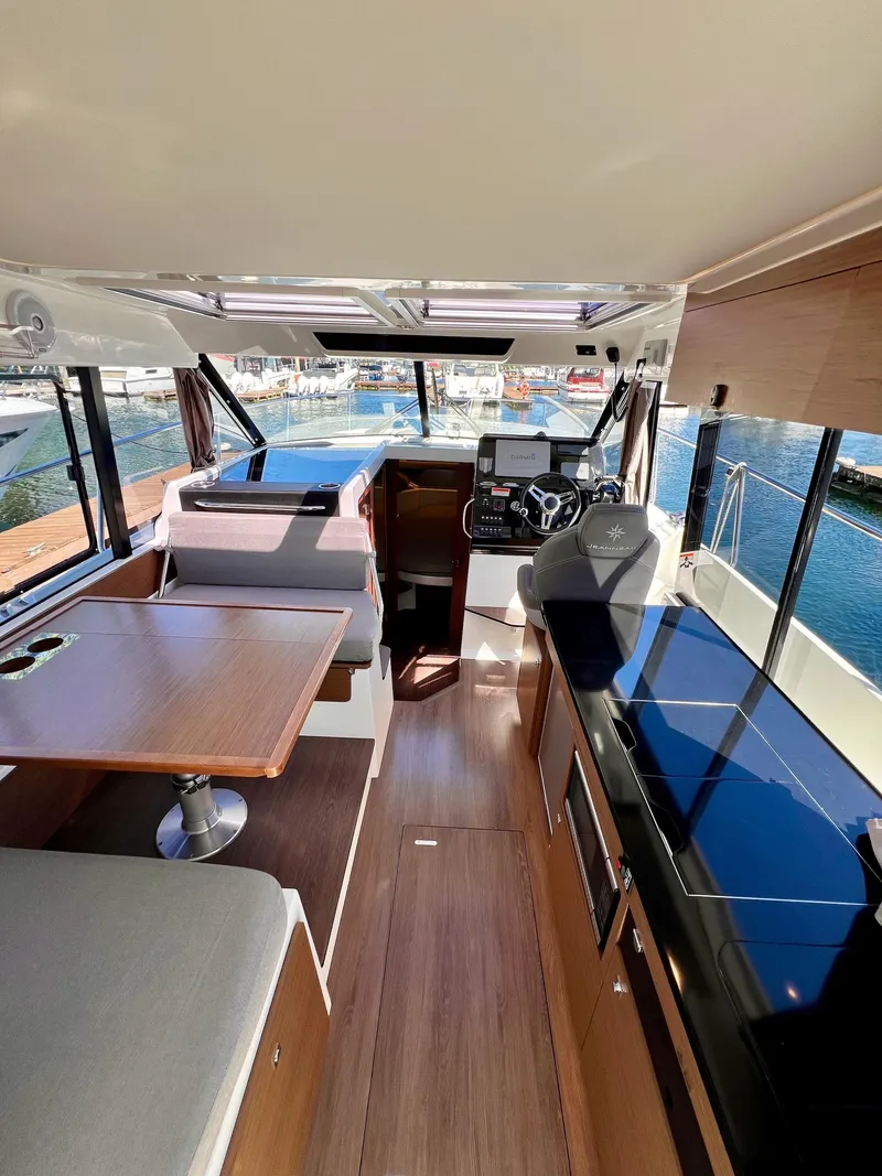 Slide: The Image of Interior of 2019 Jeanneau NC 1095 boat with helm, seating, and dining area. - 7