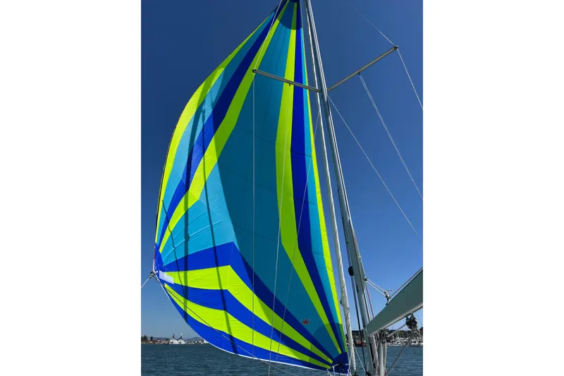 Slide: The Image of Colorful sail of a 2021 Beneteau Oceanis 30.1 against a clear blue sky. - 1