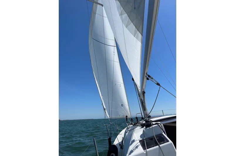 Slide: The Image of Sailing on a 2021 Beneteau Oceanis 30.1 with full sails under clear blue skies. - 12