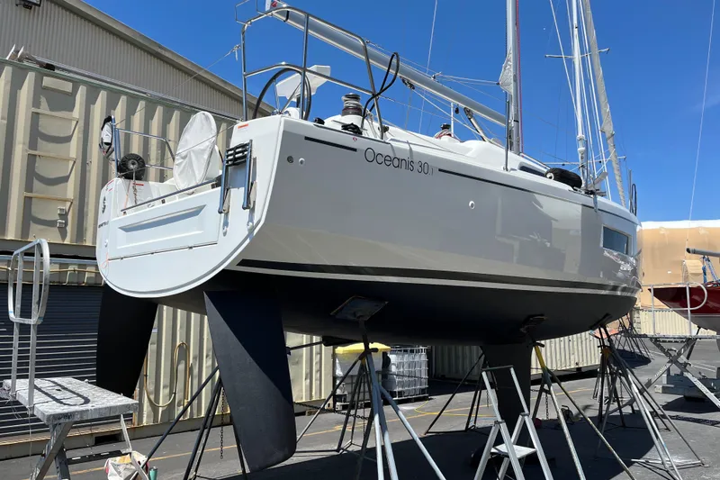 Slide: The Image of 2021 Beneteau Oceanis 30.1 sailboat on stands, in a shipyard setting. - 15