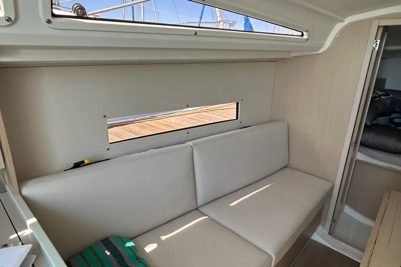 Slide: The Image of Interior of 2021 Beneteau Oceanis 30.1 yacht with beige seating and window view. - 20