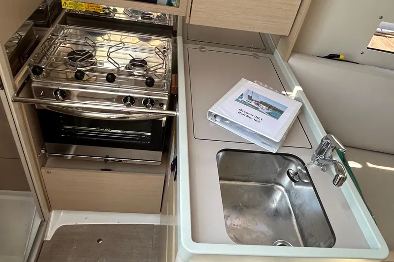 Slide: The Image of Beneteau Oceanis 30.1 yacht kitchen with stove, sink, and manual, 2021 model. - 26