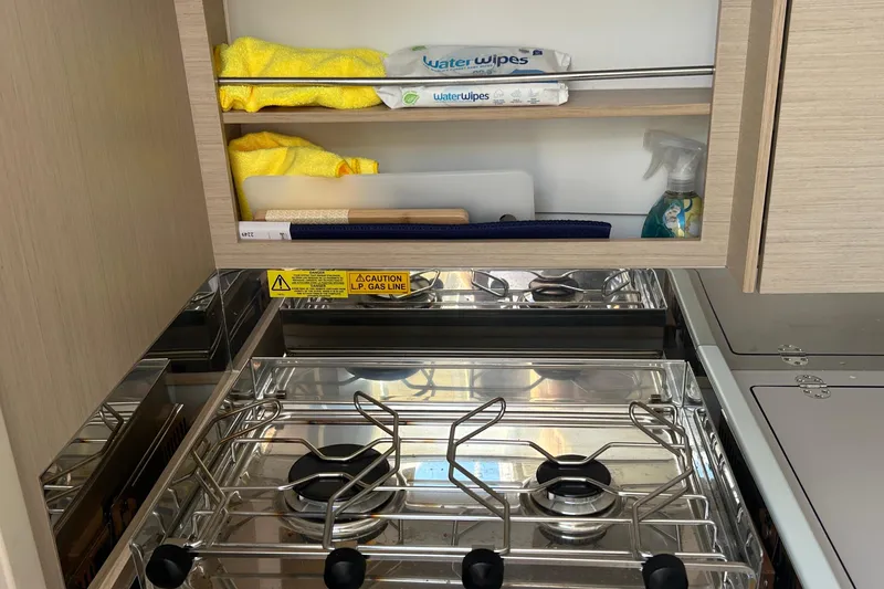 Slide: The Image of Compact kitchen area in a 2021 Beneteau Oceanis 30.1 yacht with stove and storage. - 27