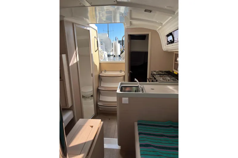 Slide: The Image of Interior of 2021 Beneteau Oceanis 30.1 yacht, featuring kitchen and seating area. - 29