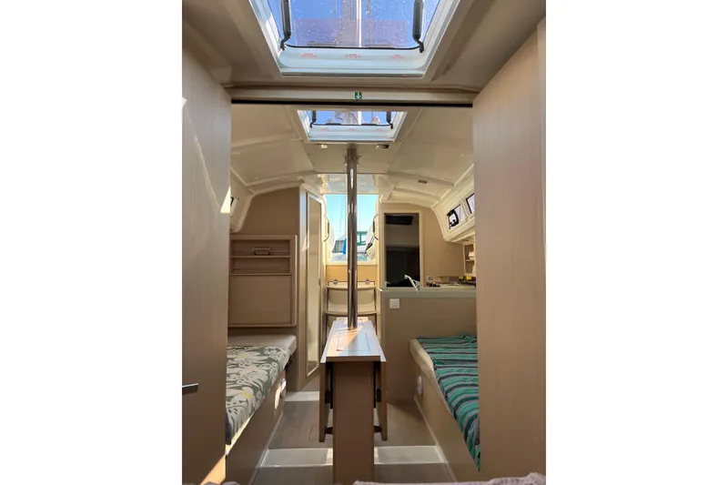 Slide: The Image of Interior of 2021 Beneteau Oceanis 30.1 sailboat, featuring cozy cabins and skylights. - 30
