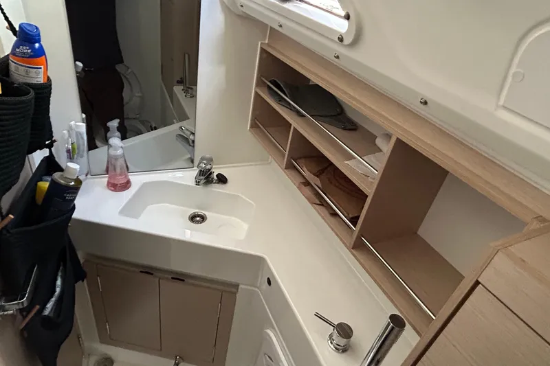 Slide: The Image of Interior of 2021 Beneteau Oceanis 30.1 yacht bathroom with sink and storage shelves. - 36