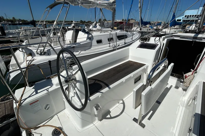 Slide: The Image of 2021 Beneteau Oceanis 30.1 sailboat cockpit with steering wheel, docked at marina. - 6