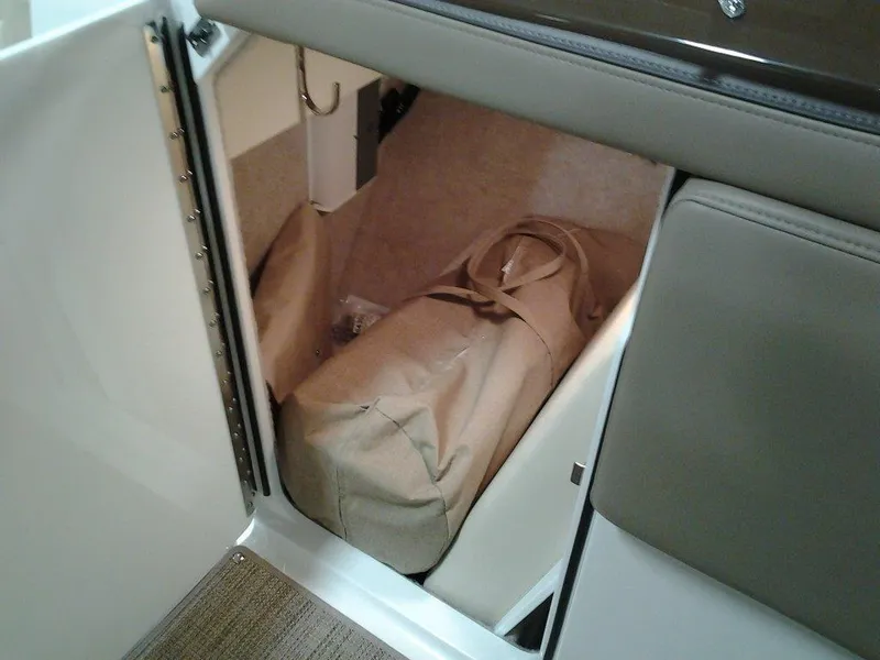 Slide: The Image of 2016 Formula 270 Bowrider storage compartment with beige bag inside. - 19