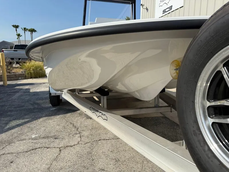 Slide: The Image of 2025 Shallow Sport 18 Sport boat on trailer, close-up view of hull and wheel. - 13