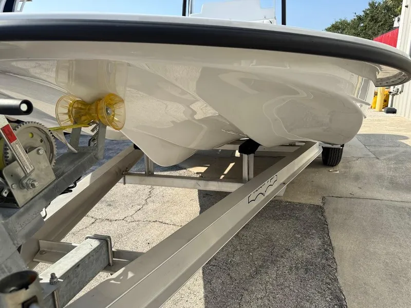 Slide: The Image of 2025 Shallow Sport 18 Sport boat on trailer, showcasing hull design and trailer mechanism. - 14