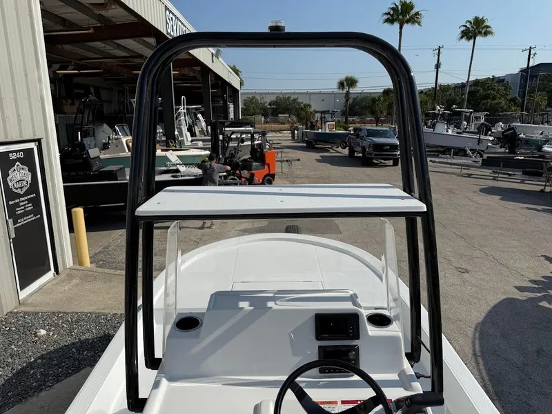 Slide: The Image of 2025 Shallow Sport 18 Sport boat at marina, featuring elevated console and steering wheel. - 16