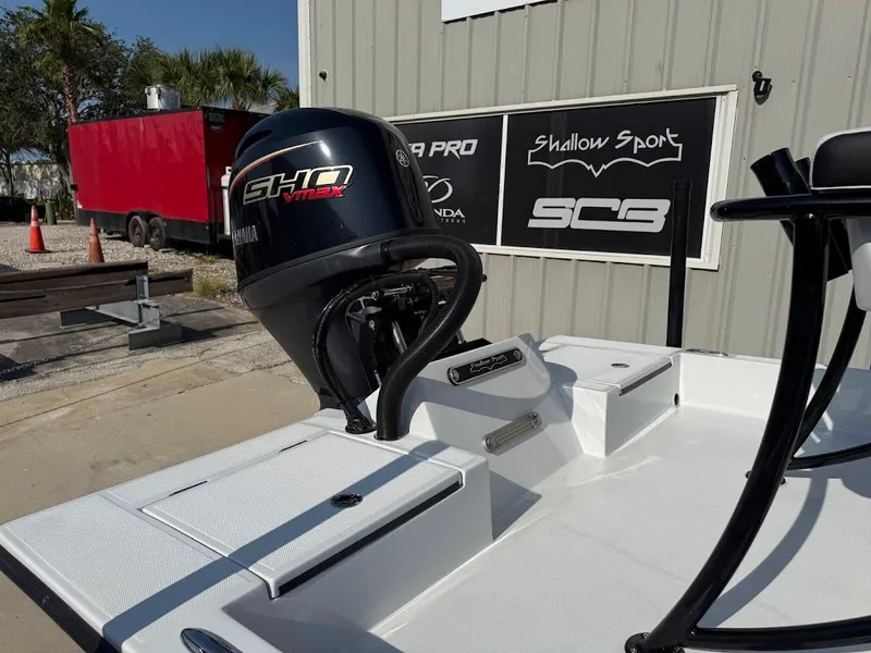 Slide: The Image of 2025 Shallow Sport 18 Sport boat with Yamaha SHO VMAX engine, parked outdoors. - 7