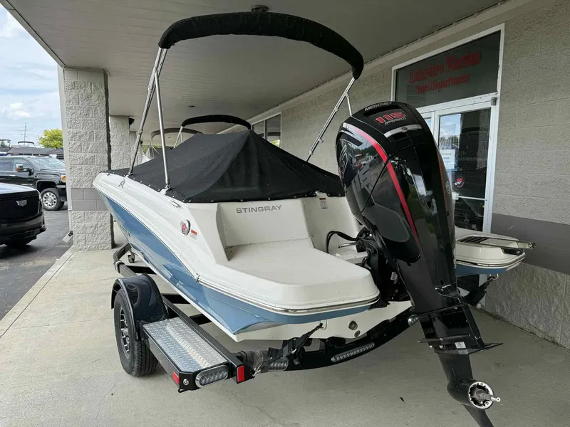 Slide: The Image of 2024 Stingray 182 SC boat with Mercury outboard motor, parked under a canopy. - 3