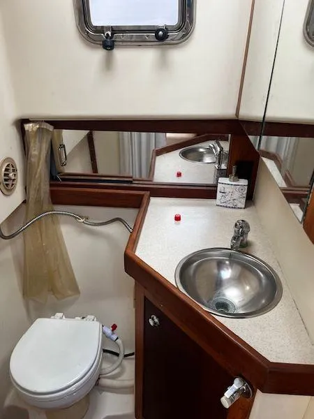 Slide: The Image of 2003 Mainship Pilot 34 bathroom with sink, toilet, and mirror. - 17