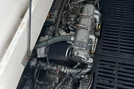 Slide: The Image of Engine compartment of a 2003 Mainship Pilot 34 boat, showing mechanical components and hoses. - 23