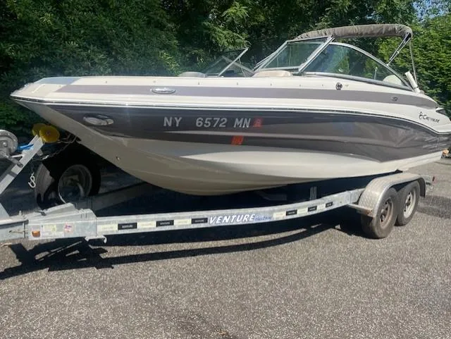 The Image of 2018 Crownline Eclipse E215 XS boat on trailer, parked outdoors. - 0