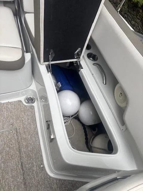 Slide: The Image of 2018 Crownline Eclipse E215 XS boat storage compartment with fenders and accessories. - 15