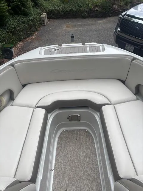 Slide: The Image of 2018 Crownline Eclipse E215 XS boat interior with cushioned seating and carpeted flooring. - 18