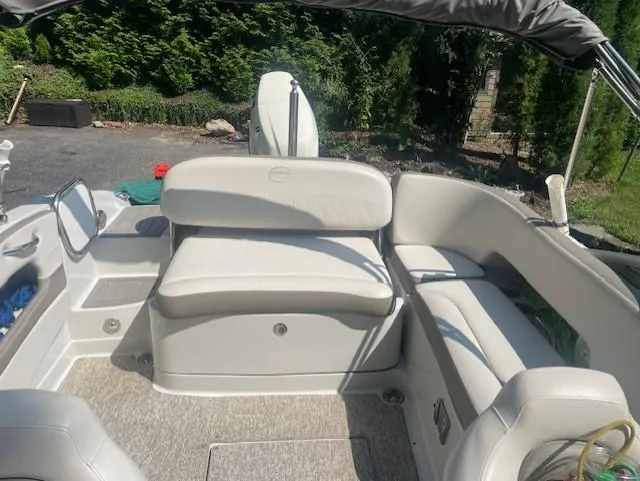 Slide: The Image of 2018 Crownline Eclipse E215 XS boat interior with white seating and outdoor setting. - 22