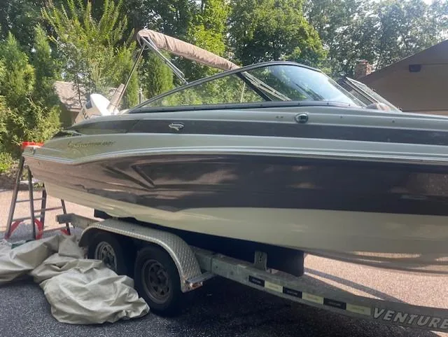 Slide: The Image of 2018 Crownline Eclipse E215 XS boat on trailer, surrounded by trees. - 3