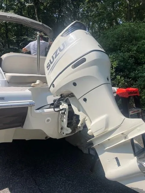 Slide: The Image of 2018 Crownline Eclipse E215 XS with Suzuki outboard motor in a wooded area. - 5