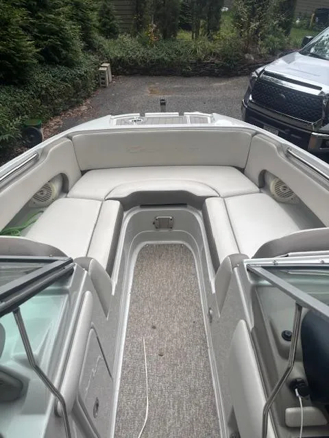 Slide: The Image of 2018 Crownline Eclipse E215 XS boat interior with white seating and carpeted floor. - 7