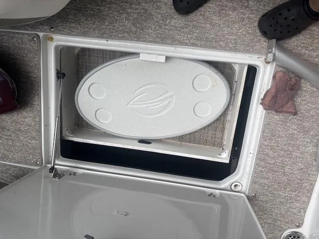 Slide: The Image of 2018 Crownline Eclipse E215 XS boat storage compartment with carpeted flooring and open hatch. - 8