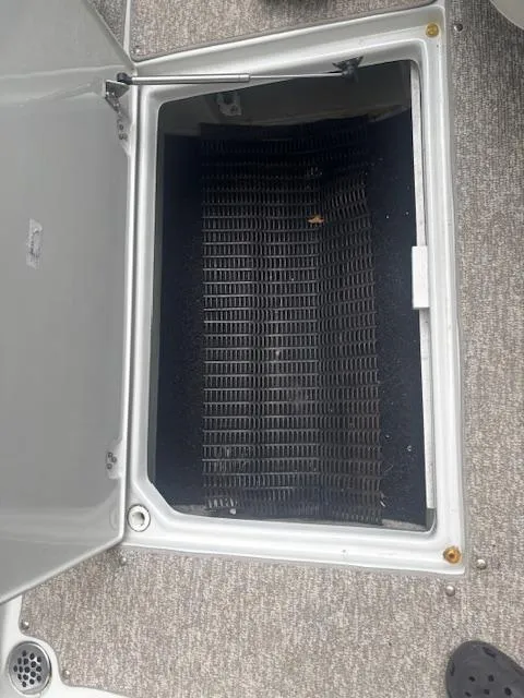 Slide: The Image of Open storage compartment on 2018 Crownline Eclipse E215 XS boat, featuring a black interior. - 9