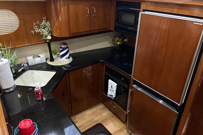 Slide: The Image of Interior of 2003 Carver 466 Motor Yacht with TV, sofa, and wooden cabinetry. - 13